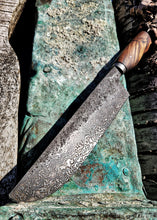 Decorative Damascus BBQ Carving knife with a wooden handle on a weathered surface