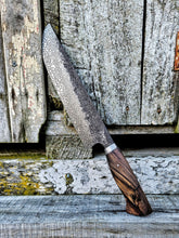 Decorative Damascus carving knife with a wooden ancient rata handle on a rustic wooden background
