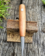 Bridge Wood handled knife on a wooden surface with grass in the background showing bridge rail wrought iron detail
