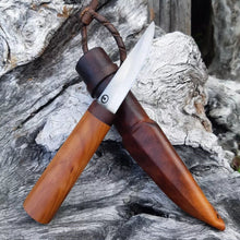 Puukko knife, the colour of the native woods matching the leather sheath, displayed on worn driftwood.