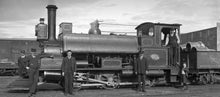 Vintage black and white photograph taken around 1908 by Albert Percy Godber of a Class F New Zealand Railways 0-6-0ST saddle tank steam locomotive, part of a class of 88 locomotives built between 1872 and 1888 locomotive with several people standing around it.