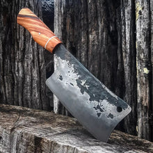 Hand forged cleaver with a wood handle on a rustic wooden chopping block