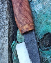 Close-up of a knife with a wooden handle on a textured surface