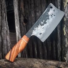 Rustic hand forged cleaver with redwood handle on a textured wood background