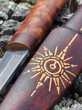 Decorative knife sheath with gold star design on a textured background