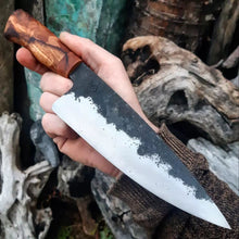 Benjamin holding the Chef Knife, showing off the hammer marks from forging the blade by hand.