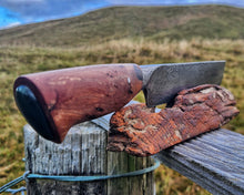 Off Track Machete with kanuka handle and inlaid Kawakawa Pounamu on a totara display stand, Tararua Ranges behind