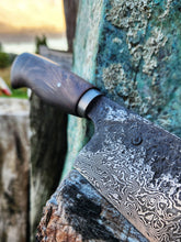 Damascus knife close up with a wooden handle on a rustic surface