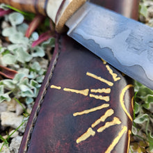Storm Hunting Knife with decorative leather sheath with gold leaf on a natural background