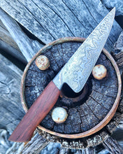Wagon Wheel Chef Knife with a wooden wagon wheel spoke handle and a Damascus blade clad in wagon wheel wrought iron, photographed on a Victorian wagon wheel hub.