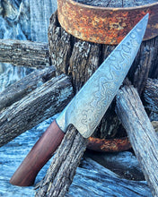 Wagon Wheel Chef Knife with a wooden wagon wheel spoke handle and a Damascus blade clad in wagon wheel wrought iron, photographed on a Victorian wagon wheel.