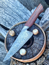 Wagon Wheel Chef Knife with a wooden wagon wheel spoke handle and a Damascus blade clad in wagon wheel wrought iron, photographed against a Victorian wagon wheel hub. 
