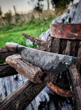 Knife with a wagon wheel wood handle and wagon wheel iron clad blade on a victorian wagon wheel with a natural background