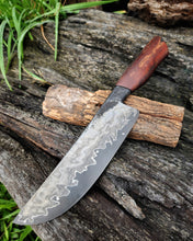 Knife with a wagon wheel wood handle resting against its wagon wheel display stand on a wooden surface