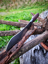 Wagon Wheel Butcher Knife with a wagon wheel wooden spoke handle with a wagon wheel wrought iron clad blade on a Victorian wagon wheel in a natural background