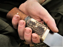 Broad Seax Chopper handle details, held in the hand of the maker Benjamin Madden.