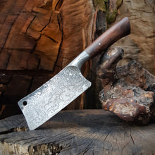 Pohutukawa Kitchen Cleaver, hand forged integral bolster, pattern welded steel on a textured wood background