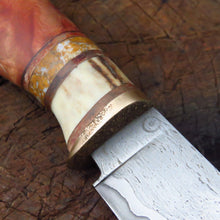 Storm Hunter knife close up of the wrought iron in the blade and the bronze, leather, antler, yellow jasper and redwood handle.