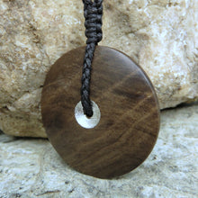 Sun and Moon Disc Pendant carved from New Zealand Fossilized Wood. This side has been gilded with silver leaf.