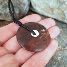 Sun and Moon Disc from Red Jasper we found at our favourite local fossicking spot. held in Marisa's hand to show its size.