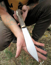 The Woodsman Seax held in the makers hand, displaying the size of the blade.